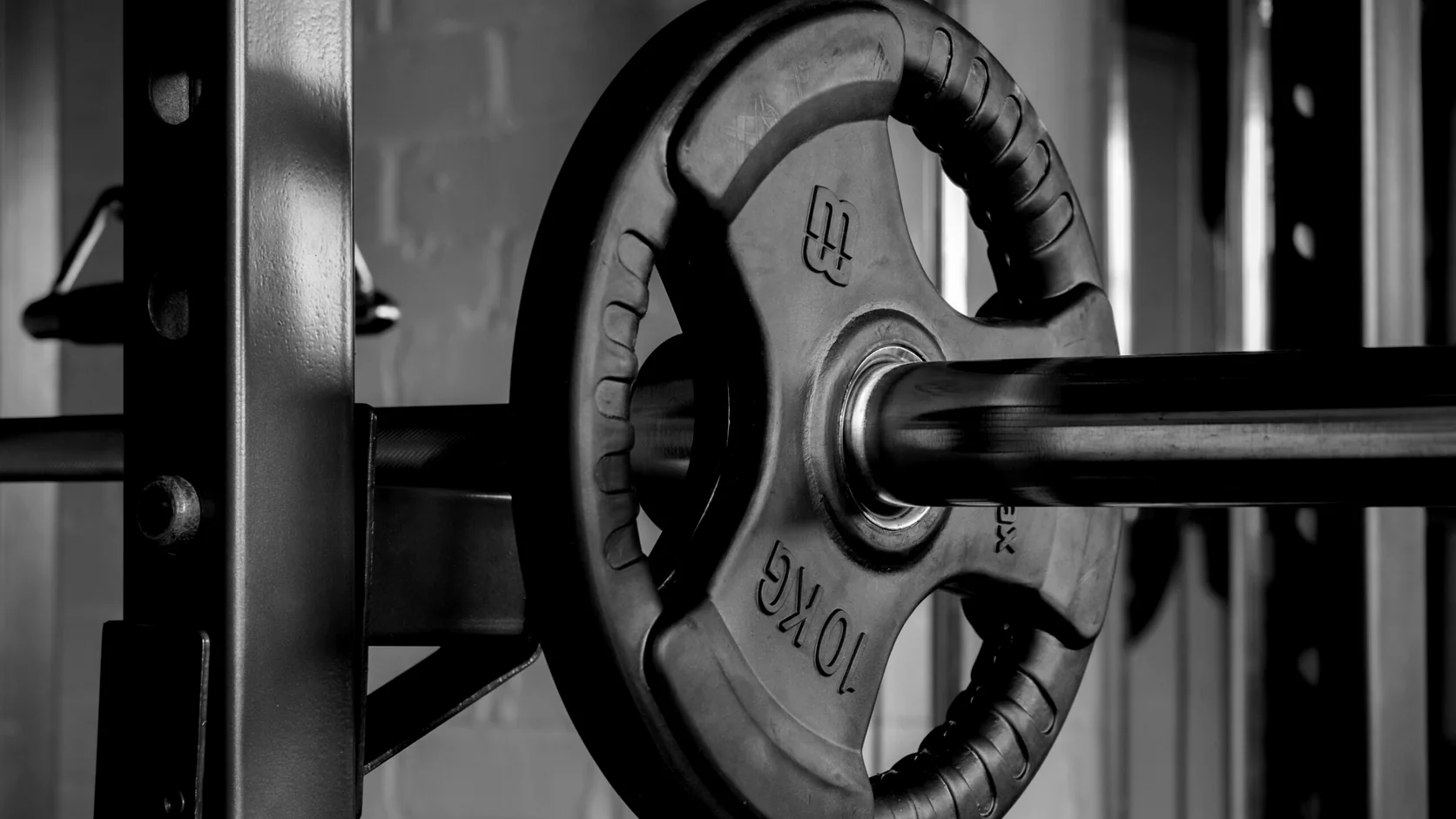 Close view of a loaded barbell and power rack.